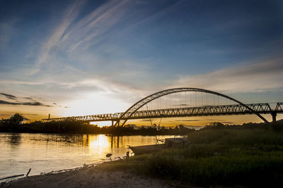View of bridge over river during sunset