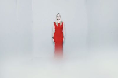 Portrait of woman standing against white background