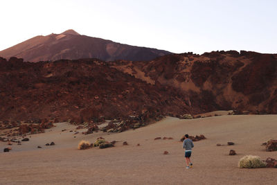 Rear view of people walking on mountain