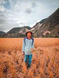 Portrait of smiling man standing on field