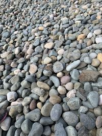 A beach covered in large grey stones