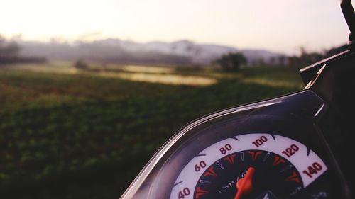 Close-up of clock on car windshield on field