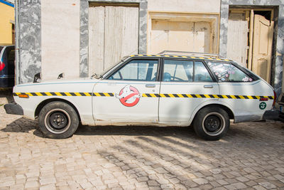 Side view of car parked on street against building