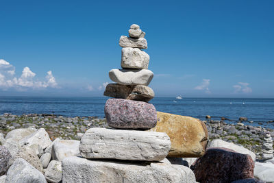 Stack of stones on beach against sky