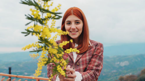 Young girl celebrates women's day with yellow mimosa flowers in hand