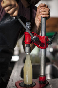 Man clamping lid on bottle of juice