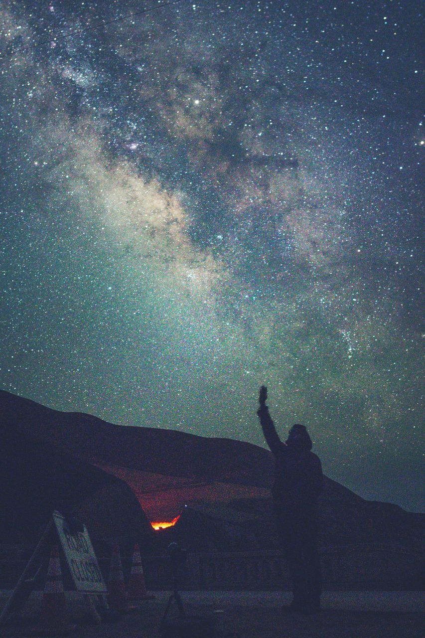 SILHOUETTE PEOPLE AGAINST STAR FIELD AT NIGHT