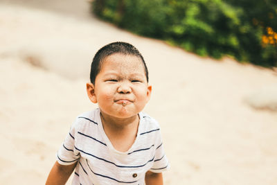 Portrait of boy wearing sunglasses on sand at beach