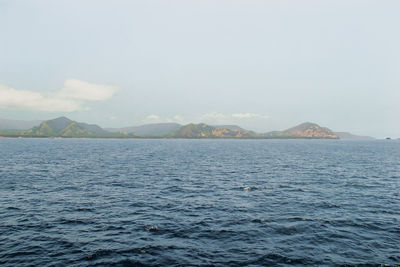 Scenic view of sea and mountains against sky