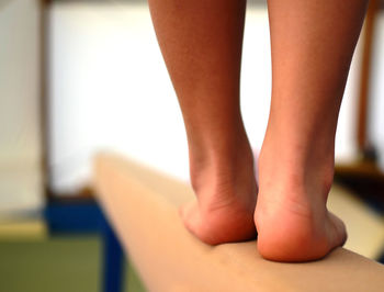 Low section of female gymnast standing on balance beam