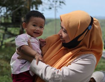 Portrait of mother and son on daughter outdoors