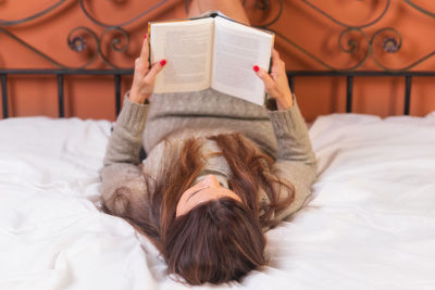 Midsection of woman lying on bed