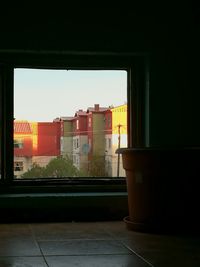 Buildings against clear sky seen through train window