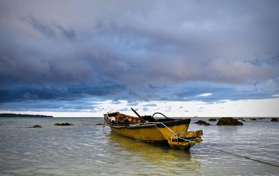 Boat moored in sea against sky