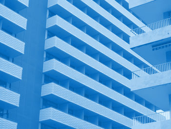 Blue toned abstract image of large modern highrise modern apartment buildings with angular balconies