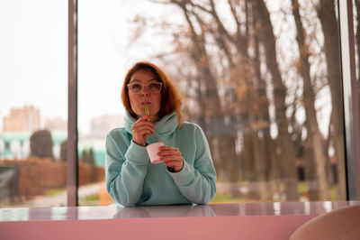 Portrait of young woman drinking glass