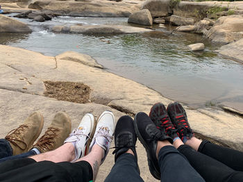 Low section of people sitting on rock