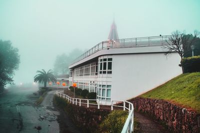 View of road by buildings against sky