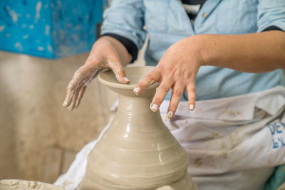 Midsection of man making pot