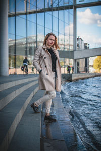 Young woman standing on steps by canal