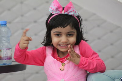 Close-up of thoughtful girl wearing headband while standing by sofa at home