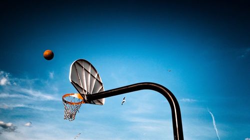 Low angle view of basketball flying towards hoop