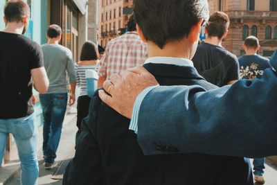 Rear view of people standing in city