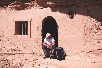 Full length of man sitting at entrance