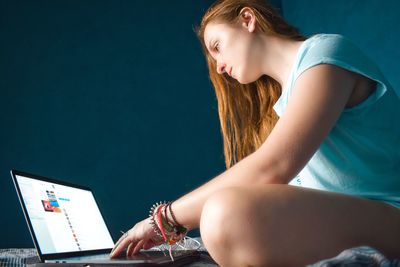 Midsection of woman using mobile phone while sitting on table