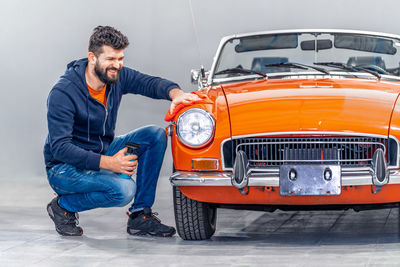 Side view of man sitting on car