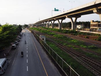 Vehicles on road against sky in city