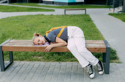 Side view of woman sitting on bench