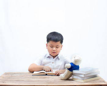 Cute boy with toy against white background