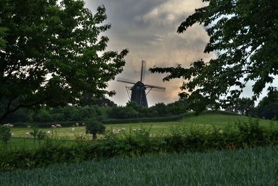 Traditional windmill on field against sky