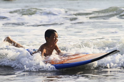 Full length of shirtless boy in sea