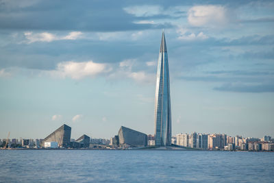 View of modern buildings in city against cloudy sky