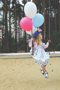 Rear view of woman with pink balloon balloons against trees