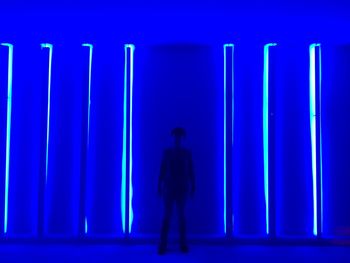 Full length of silhouette man standing against illuminated wall