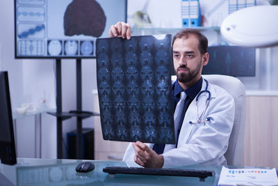 Portrait of female doctor using mobile phone in office