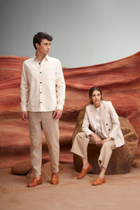 Portrait of young woman standing against sky