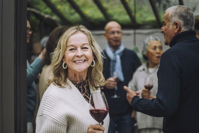 Portrait of happy senior woman with friends at dinner party