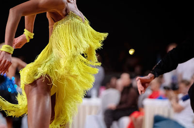 Graceful female dancer in yellow dress at dance sport