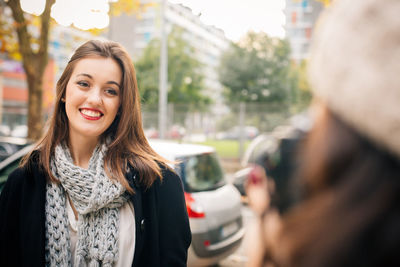 Portrait of smiling young woman in city