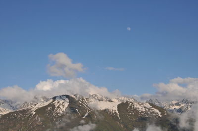 Scenic view of snowcapped mountains against blue sky