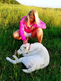 Woman stroking dog on field