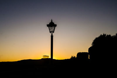 Silhouette street light against clear sky during sunset