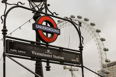 Low angle view of information sign against sky