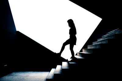 Side view of silhouette woman standing on steps