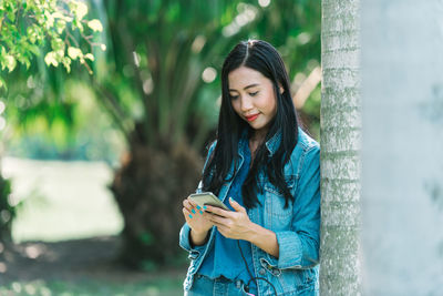 Young woman using mobile phone outdoors