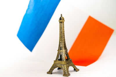 Close-up of eiffel tower centerpiece against flag on white background